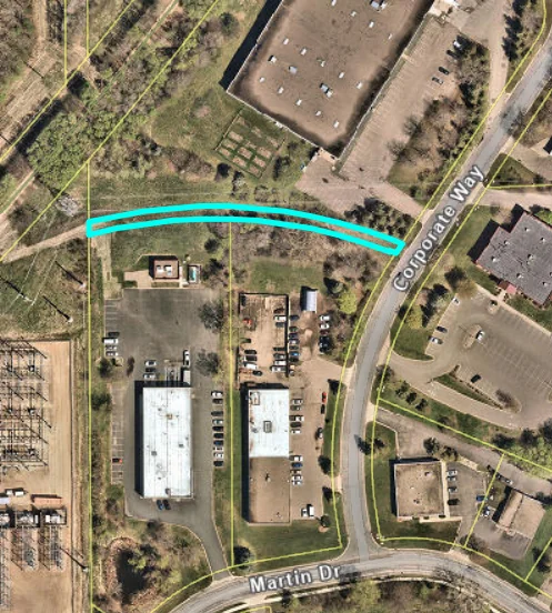 Aerial map with the garden site outlined in blue: a long strip north of the buildings on Corporate Way, near Martin Drive